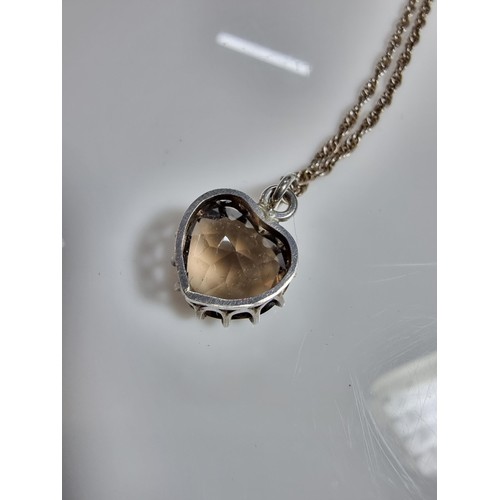 355 - A 925 silver pendant inset with a large faceted heart formed smokey quartz gemstone. Set on a 16