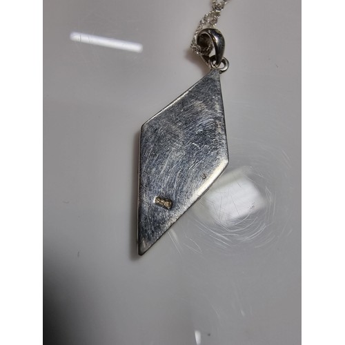 365 - A 925 silver and mother of pearl pendant with an attractive design. Set on a long 24