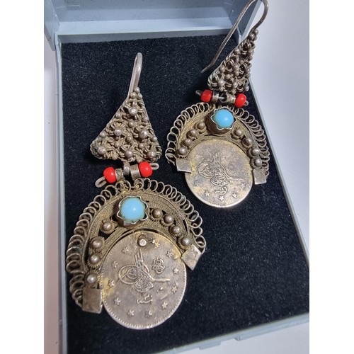 369 - A pair of unusual middle eastern ornate drop earrings, inset with a coin turquoise and coral beads. ... 