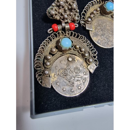 369 - A pair of unusual middle eastern ornate drop earrings, inset with a coin turquoise and coral beads. ... 