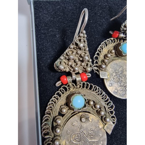 369 - A pair of unusual middle eastern ornate drop earrings, inset with a coin turquoise and coral beads. ... 