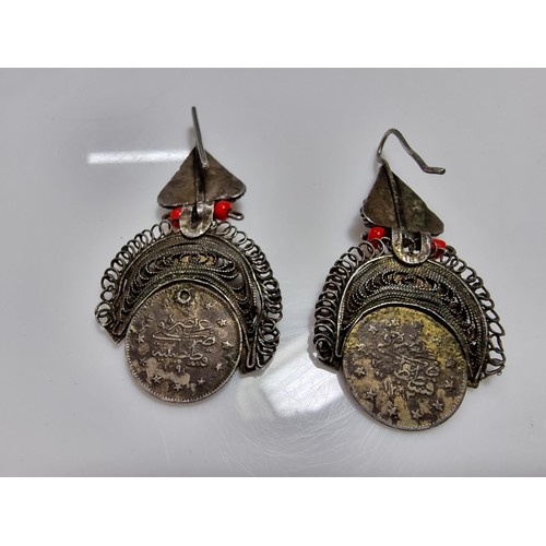369 - A pair of unusual middle eastern ornate drop earrings, inset with a coin turquoise and coral beads. ... 