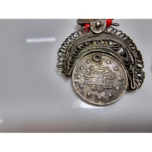 369 - A pair of unusual middle eastern ornate drop earrings, inset with a coin turquoise and coral beads. ... 