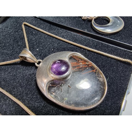 371 - An ornate 925 silver pendant inset with a large oval rutilated quartz stone and an amethyst cabochon... 