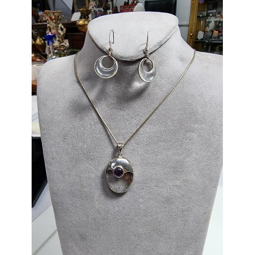 371 - An ornate 925 silver pendant inset with a large oval rutilated quartz stone and an amethyst cabochon... 