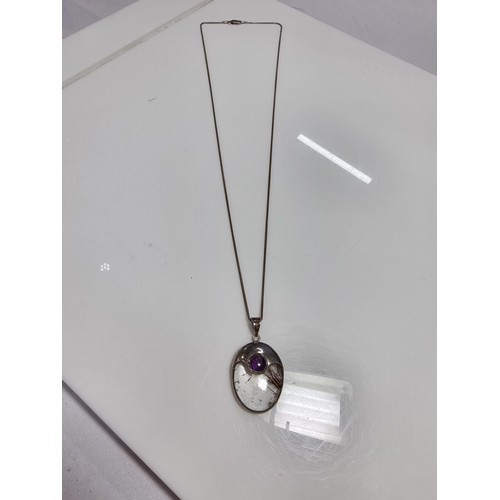 371 - An ornate 925 silver pendant inset with a large oval rutilated quartz stone and an amethyst cabochon... 