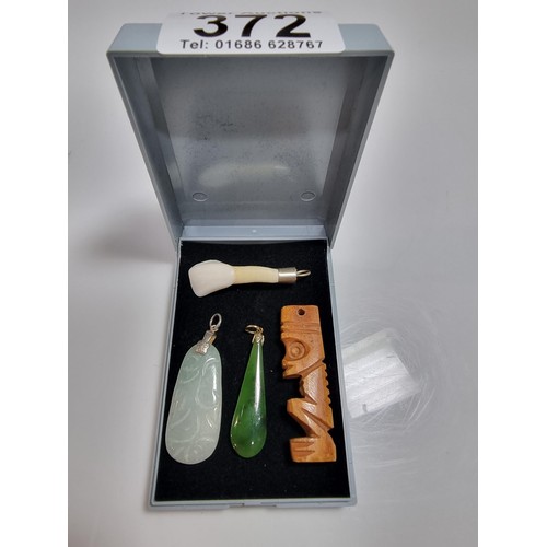 372 - 4 vintage ethnic style pendants including a jade pendant (tested) a green serpentine pendant, a carv... 