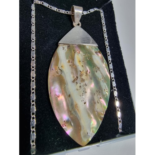 374 - A large 925 silver m.o.p. pendant with an unusual natural design, set on a very long 26