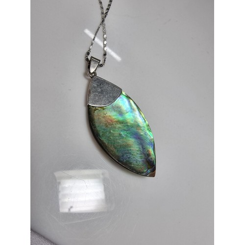 374 - A large 925 silver m.o.p. pendant with an unusual natural design, set on a very long 26