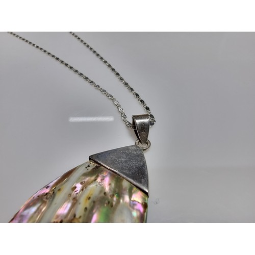 374 - A large 925 silver m.o.p. pendant with an unusual natural design, set on a very long 26