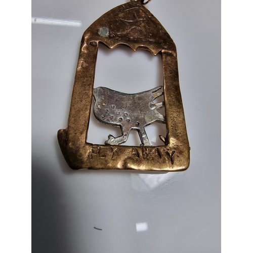 376 - An unusual vintage arts & crafts copper and pewter large pendant of a bird in an archway scene. Engr... 