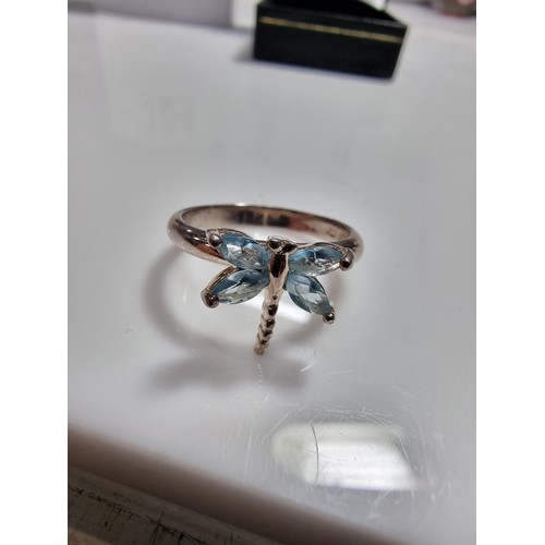 384 - A new old stock 925 silver dragonfly ring inset with blue stones.
size P, in a new quality ring box.