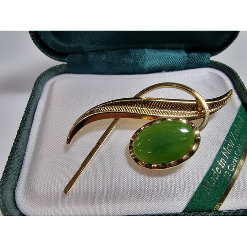 391 - A cased unused brooch by Ariki inset with nephrite jade made in New Zealand 22ct gold plated.