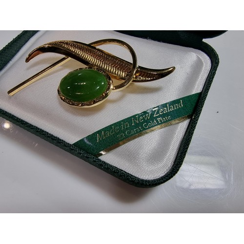 391 - A cased unused brooch by Ariki inset with nephrite jade made in New Zealand 22ct gold plated.