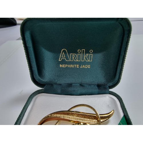 391 - A cased unused brooch by Ariki inset with nephrite jade made in New Zealand 22ct gold plated.