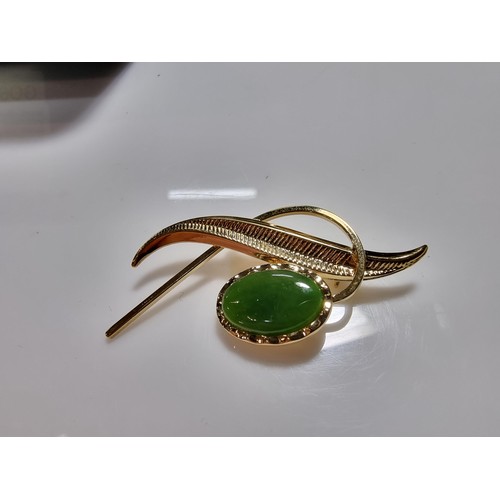 391 - A cased unused brooch by Ariki inset with nephrite jade made in New Zealand 22ct gold plated.