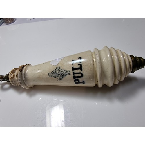 395 - An antique ceramic and brass lavatory chain handle.
in good overall condition with minor chips to th... 