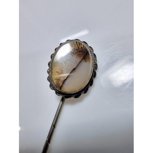 397 - A tested as silver antique stick pin inset with a dendrite crystal that has a natural multi branchin... 