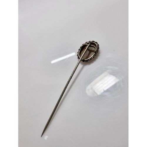 397 - A tested as silver antique stick pin inset with a dendrite crystal that has a natural multi branchin... 
