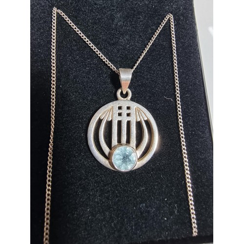 403 - A 925 silver pendant with a Rennie Macintosh design inset with a blue topaz stone set on an 18