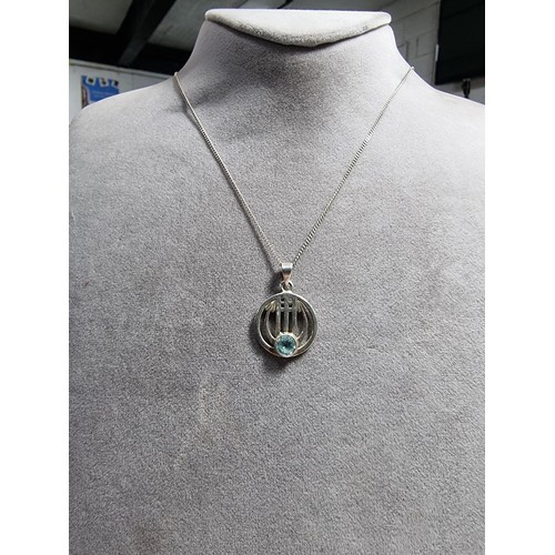 403 - A 925 silver pendant with a Rennie Macintosh design inset with a blue topaz stone set on an 18