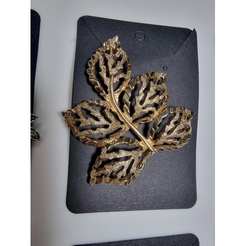 427 - A quantity of 6 ornate costume brooches including a signed designer leaf formed costume brooch by Sa... 