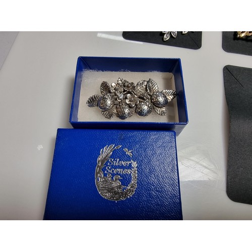 427 - A quantity of 6 ornate costume brooches including a signed designer leaf formed costume brooch by Sa... 