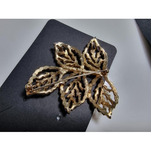 427 - A quantity of 6 ornate costume brooches including a signed designer leaf formed costume brooch by Sa... 