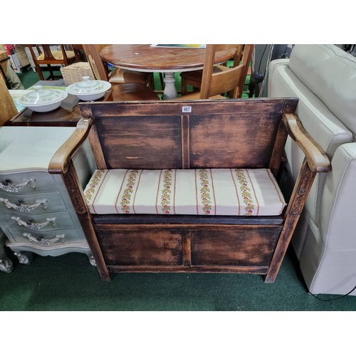 487 - Antique solid oak settle with a carved design to the front featuring an upholstered cushion seat rev... 