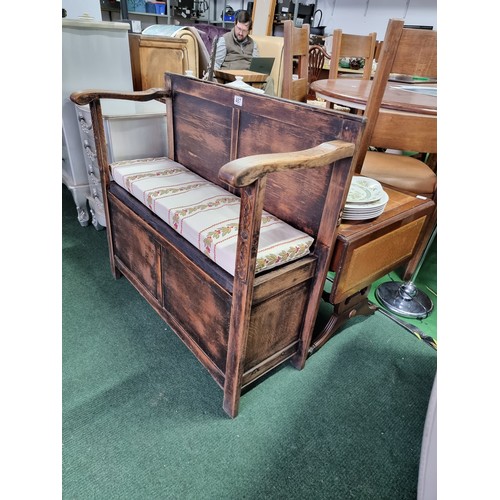 487 - Antique solid oak settle with a carved design to the front featuring an upholstered cushion seat rev... 