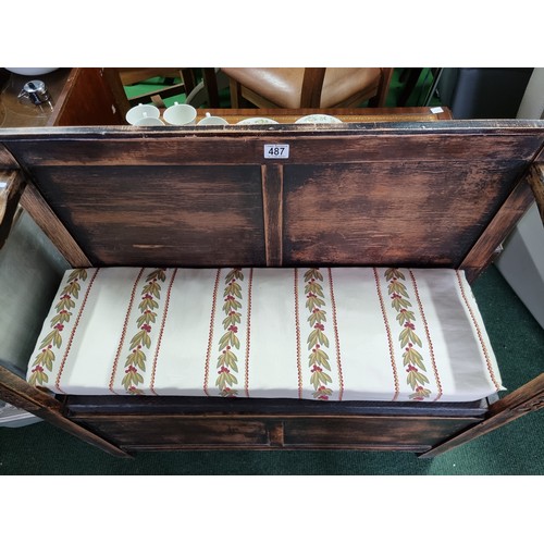 487 - Antique solid oak settle with a carved design to the front featuring an upholstered cushion seat rev... 