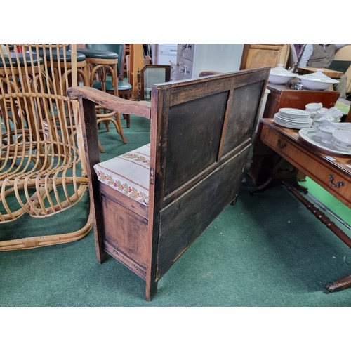 487 - Antique solid oak settle with a carved design to the front featuring an upholstered cushion seat rev... 