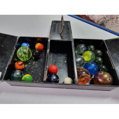 158 - A vintage black Japanned metal tin containing a quantity of collectable marbles all in good order.