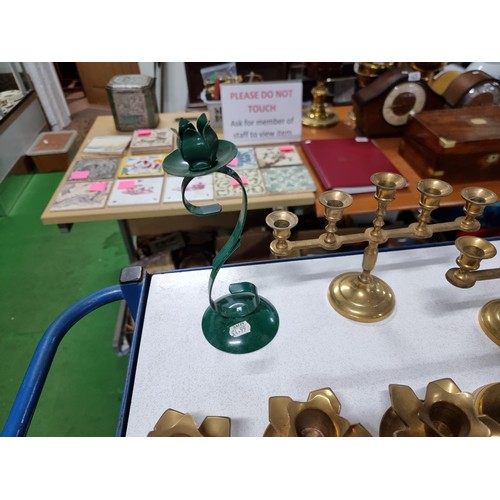 194 - A large quantity of various brass candlesticks all in a wicker basket with wooden handles.