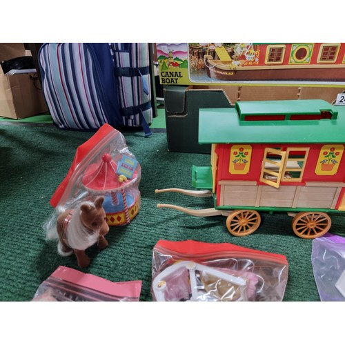 240 - A large collection of Tomy Sylvanian families including a boxed canal boat, 2 houses, gypsy caravan,... 