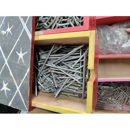 25 - A 9 drawer wooden storage chest containing a quantity of nails, link chain and angle brackets, along... 