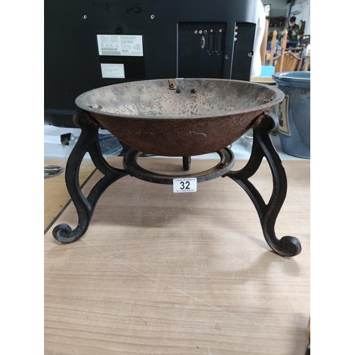 32 - An antique cast iron fire pit standing on 3 cast iron scroll legs in good order. Height 25cm, base d... 