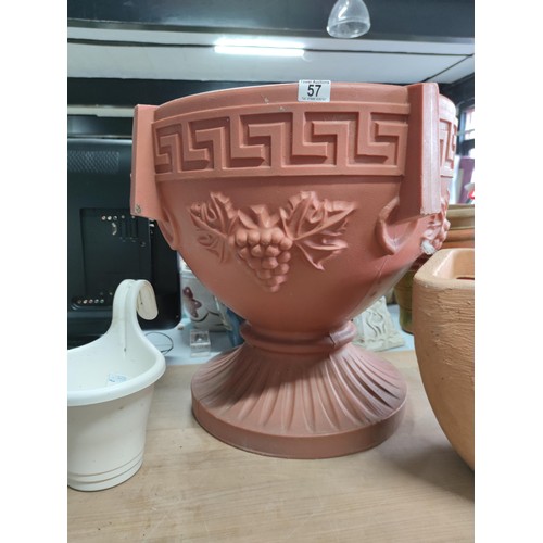 57 - A large quantity of plastic planter including a large urn shaped planter on a pedestal, along with 6... 