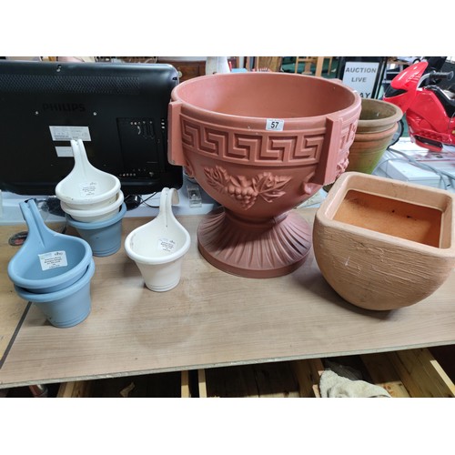 57 - A large quantity of plastic planter including a large urn shaped planter on a pedestal, along with 6... 