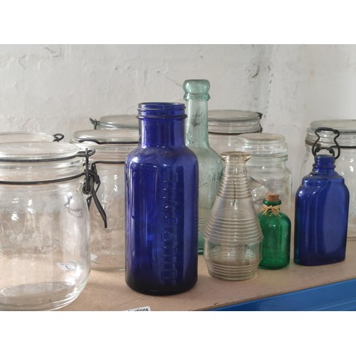 107 - A collection of glassware including 6 kilner jars, 4.5l empty whisky bottle, coloured glass bottles,... 