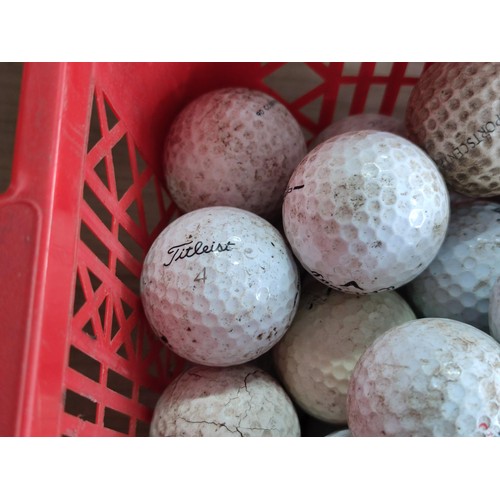 111 - A small plastic crate containing over 50 golf balls, including pinnacle, Dunlop, Callaway, Titleist,... 