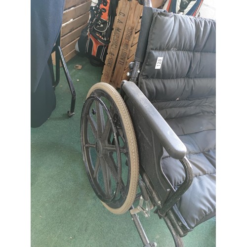 128 - An oversized collapsible wheelchair with padded seat and foot rests, large wheels for self drive. In... 