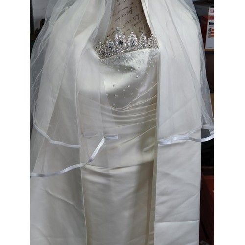 134 - An off the shoulder sequin topped cream wedding dress with matching cream full length scarf, veil an... 