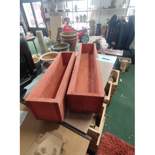 74 - 2 large wooden planters, 2 large elongated wooden planters, both been treated for outdoor use.
Longe... 