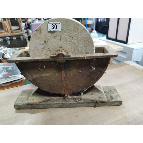 30 - Vintage grinding stone with wooden handle on wooden plinth along with a shoe last and a large cast i... 