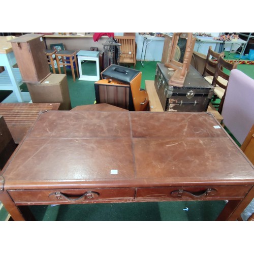 515 - Leather covered desk with two drawers and studded corner reinforcements. Drawers operate of metal ru... 