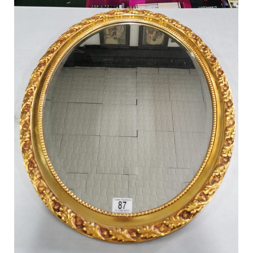 87 - Gilt oval mirror 69cm high by 53cm wide