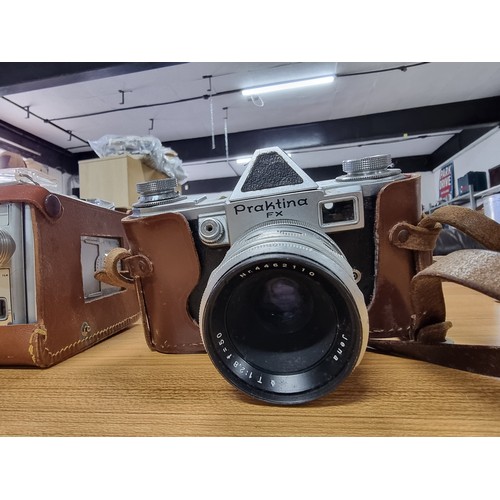 57 - A quantity of vintage cameras and lenses to include  a Praktina FX 35mm camera fitted with a Carl Ze... 