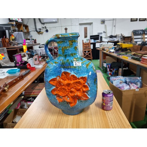 320 - A very large unusual West German glazed jug vase in blue and green with an orange flower design to t... 