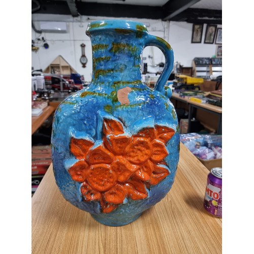 320 - A very large unusual West German glazed jug vase in blue and green with an orange flower design to t... 